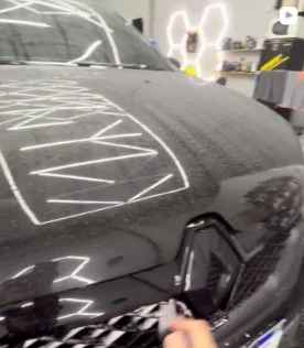 Reel no Instagram: capô de um carro preto com marcações de trabalho de estética automotiva